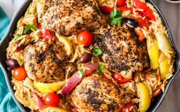 overhead image of greek chicken orzo in skillet.