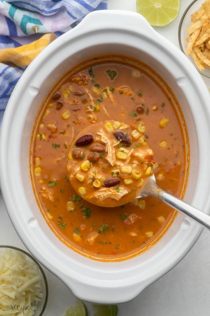 overhead shot of chicken taco soup being scooped out of slow cooker.