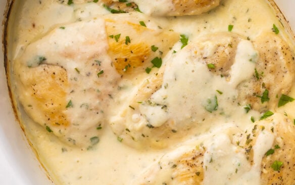 close up of creamy garlic chicken in white slow cooker.