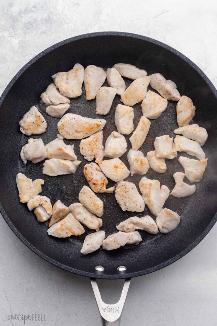cooked pieces of chicken breast in black pan.