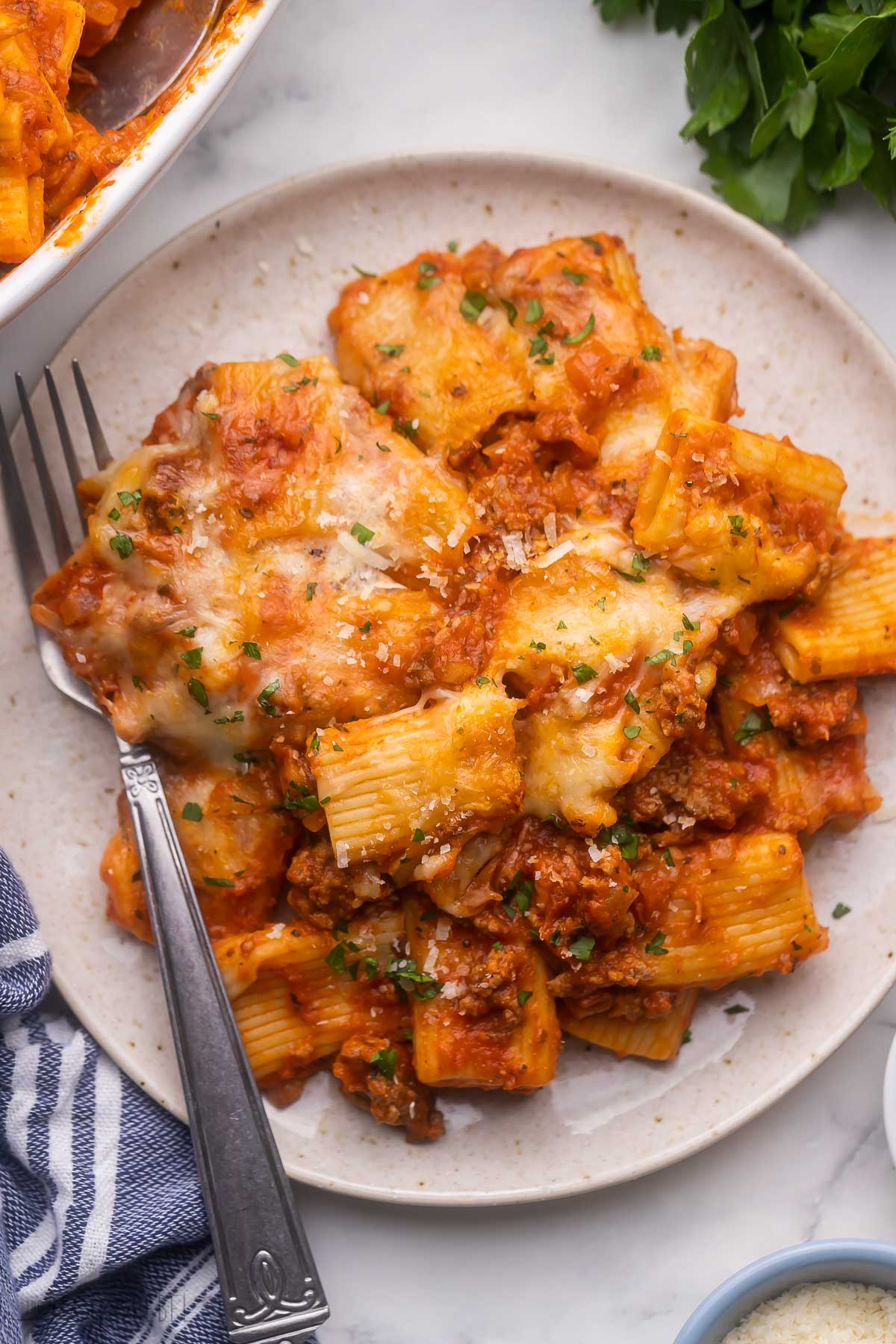 plate filled with rigatoni pasta bake and a fork beside.