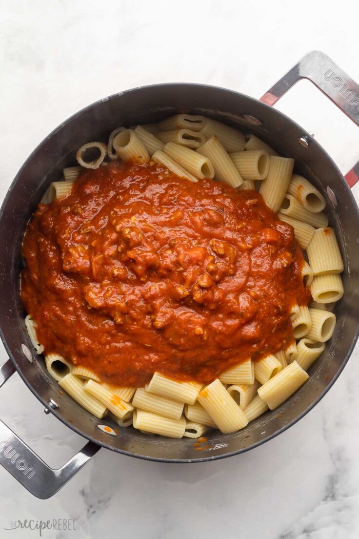 large pot filled with cooked pasta and sauce added on top.