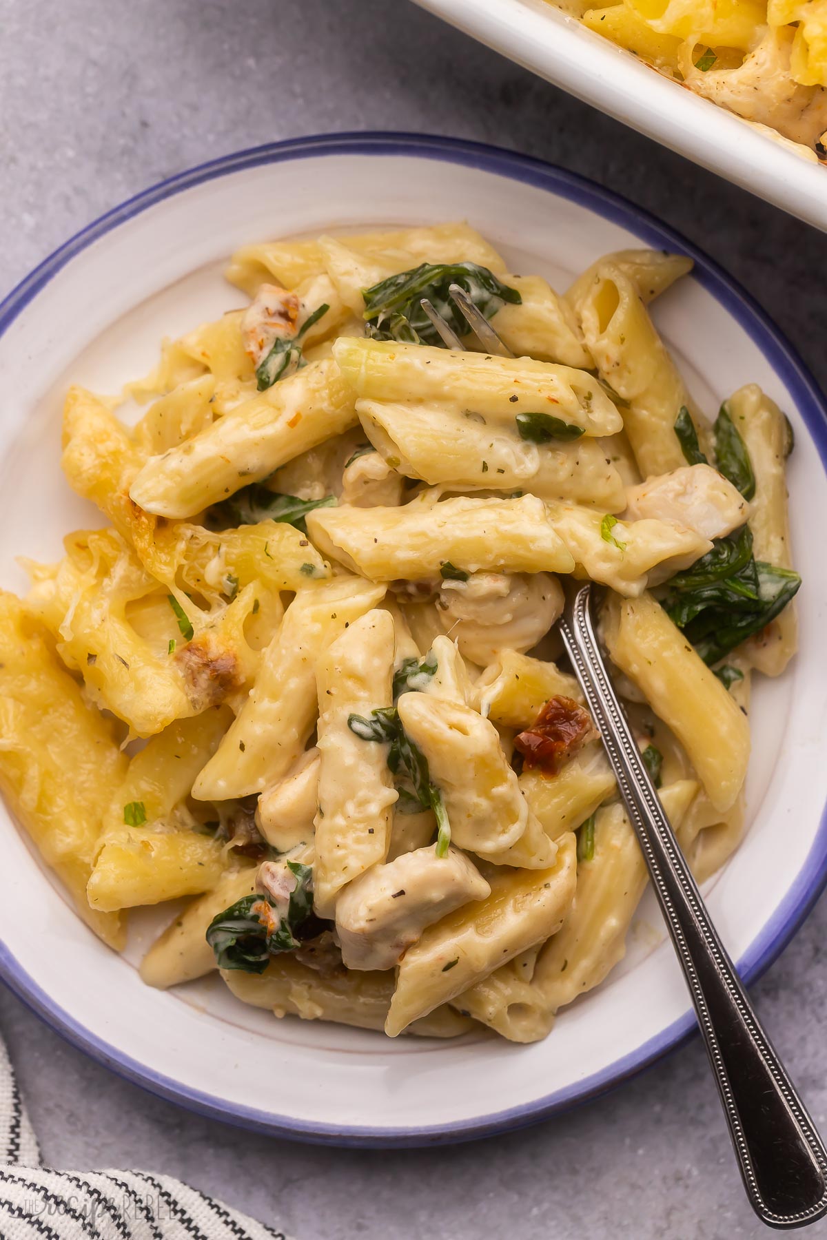 overhead shot of a white plate filled with tuscan chicken pasta bake.