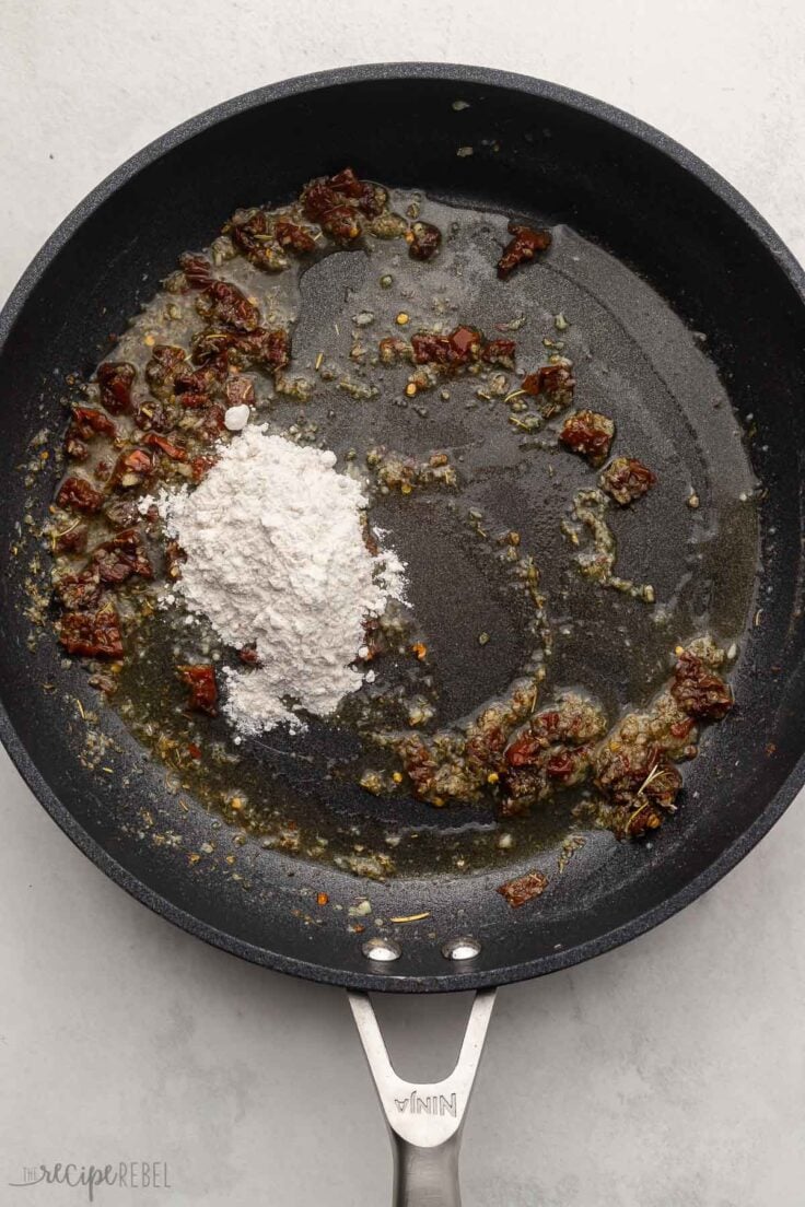 overhead view of black frying pan with corn starch added to other ingredients.