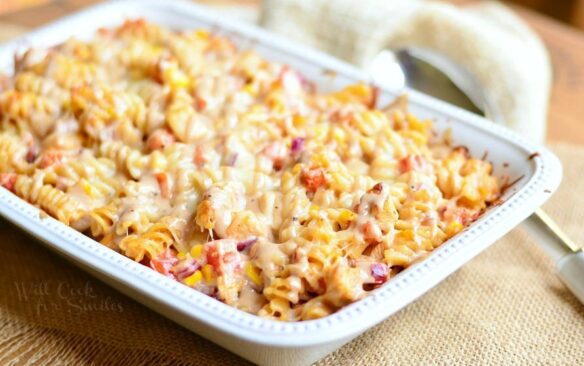 A white casserole dish is filled with baked bbq ranch casserole.