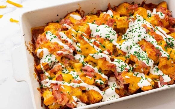 buffalo chicken casserole is garnished with a drizzle of sour cream.