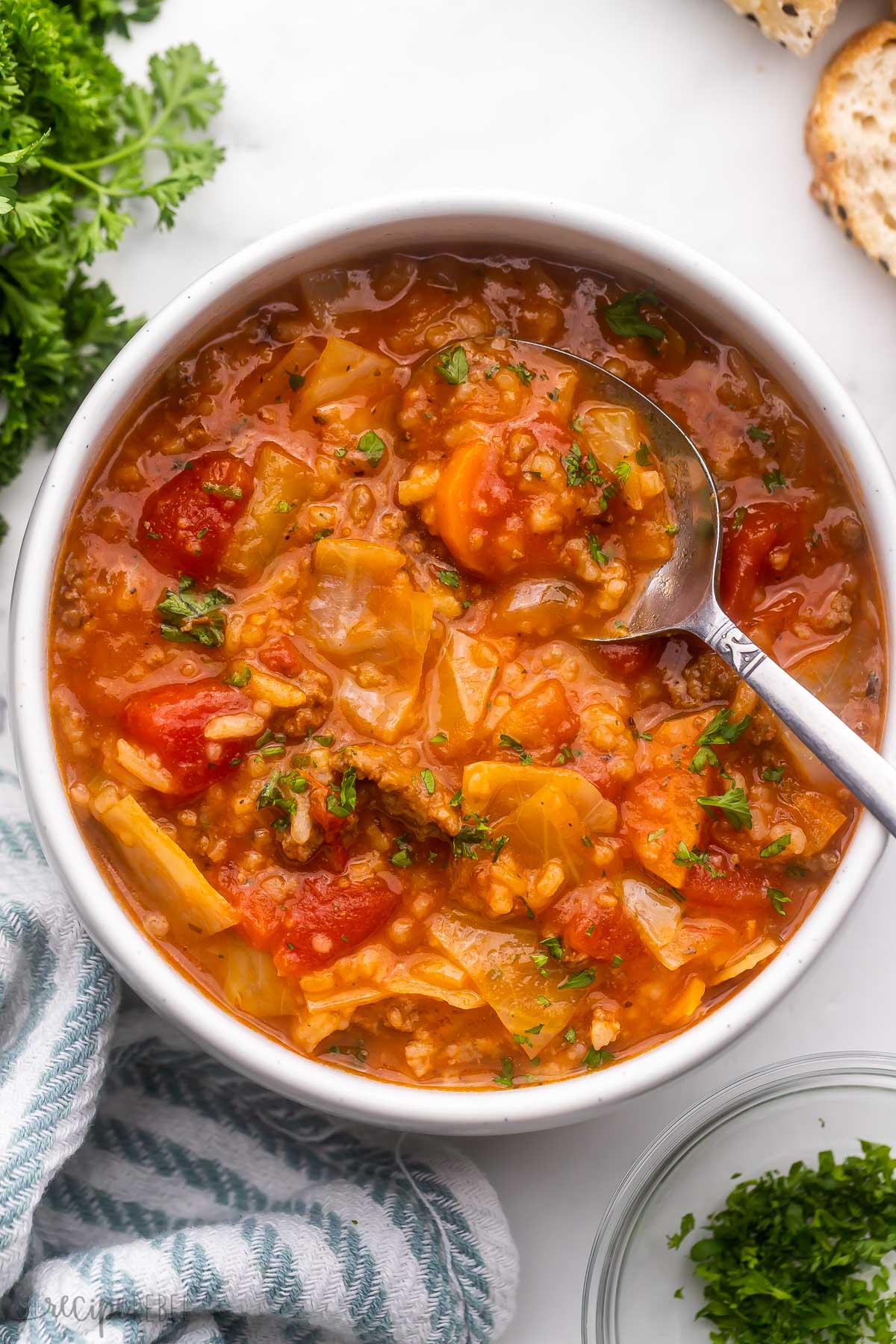 overhead image of bowl of cabbage roll soup with spoon.