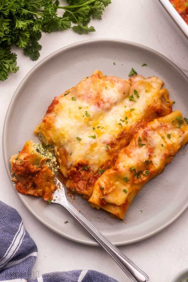 grey plate and fork with a piece of three cheese cannelloni.