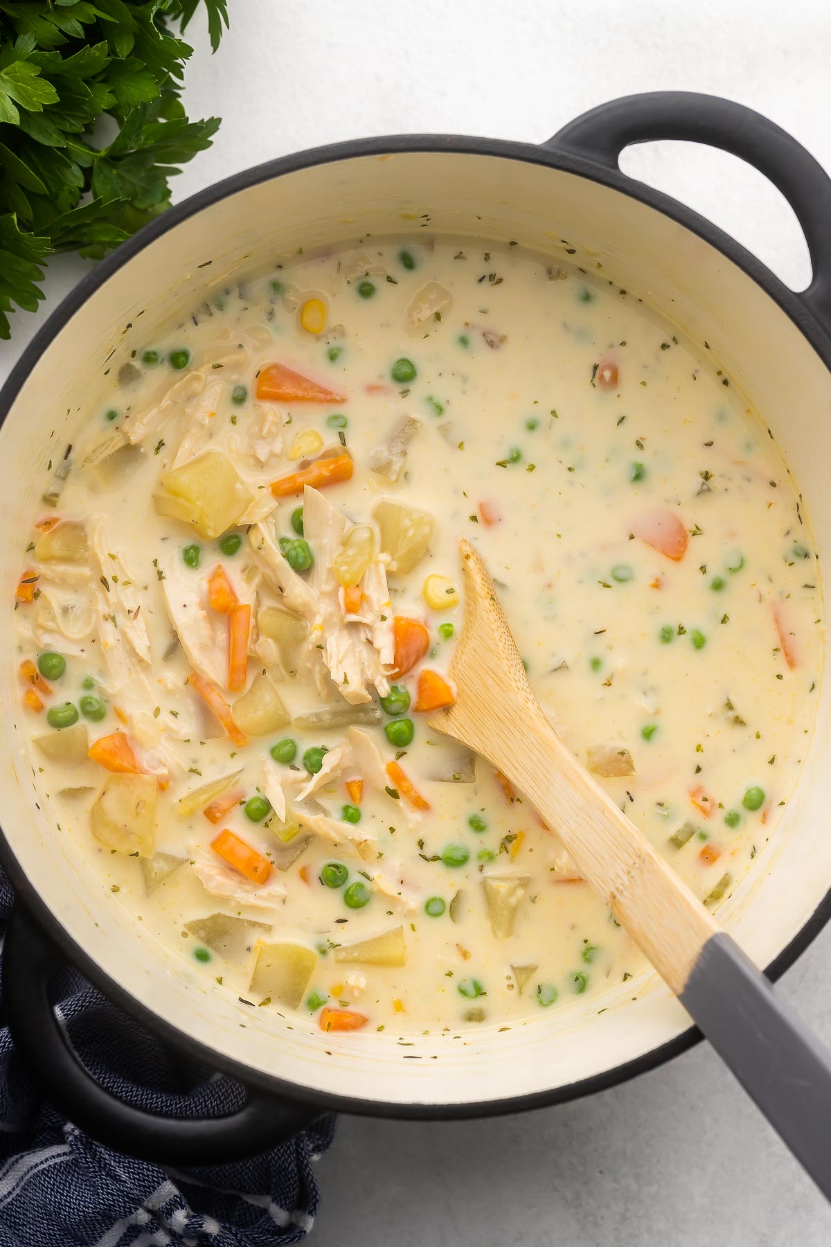 large pot filled with chicken pot pie soup and wooden ladle.