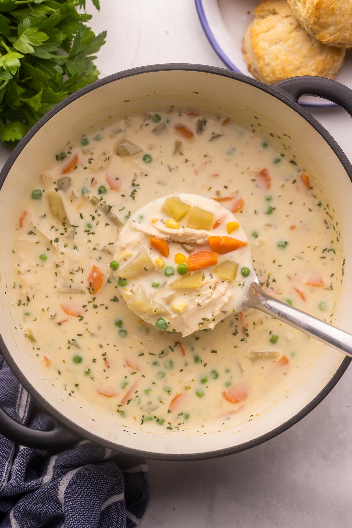 chicken pot pie soup being scooped out of a large pot.
