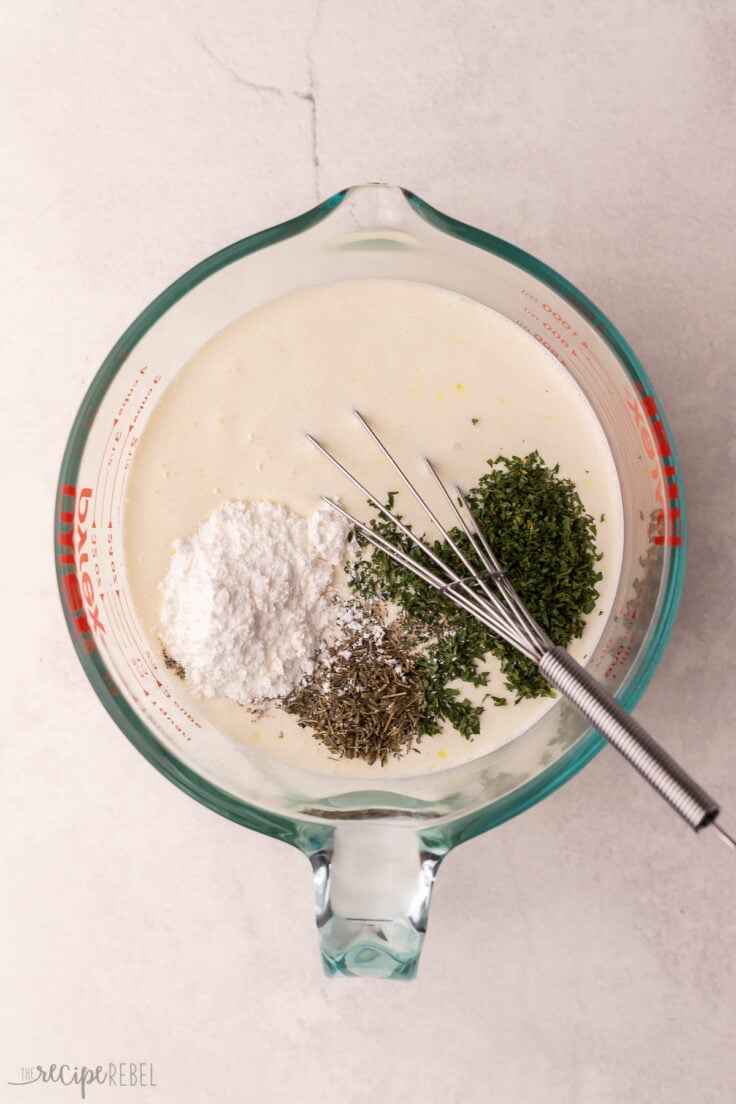 glass measuring cup filled with cream and other ingredients.