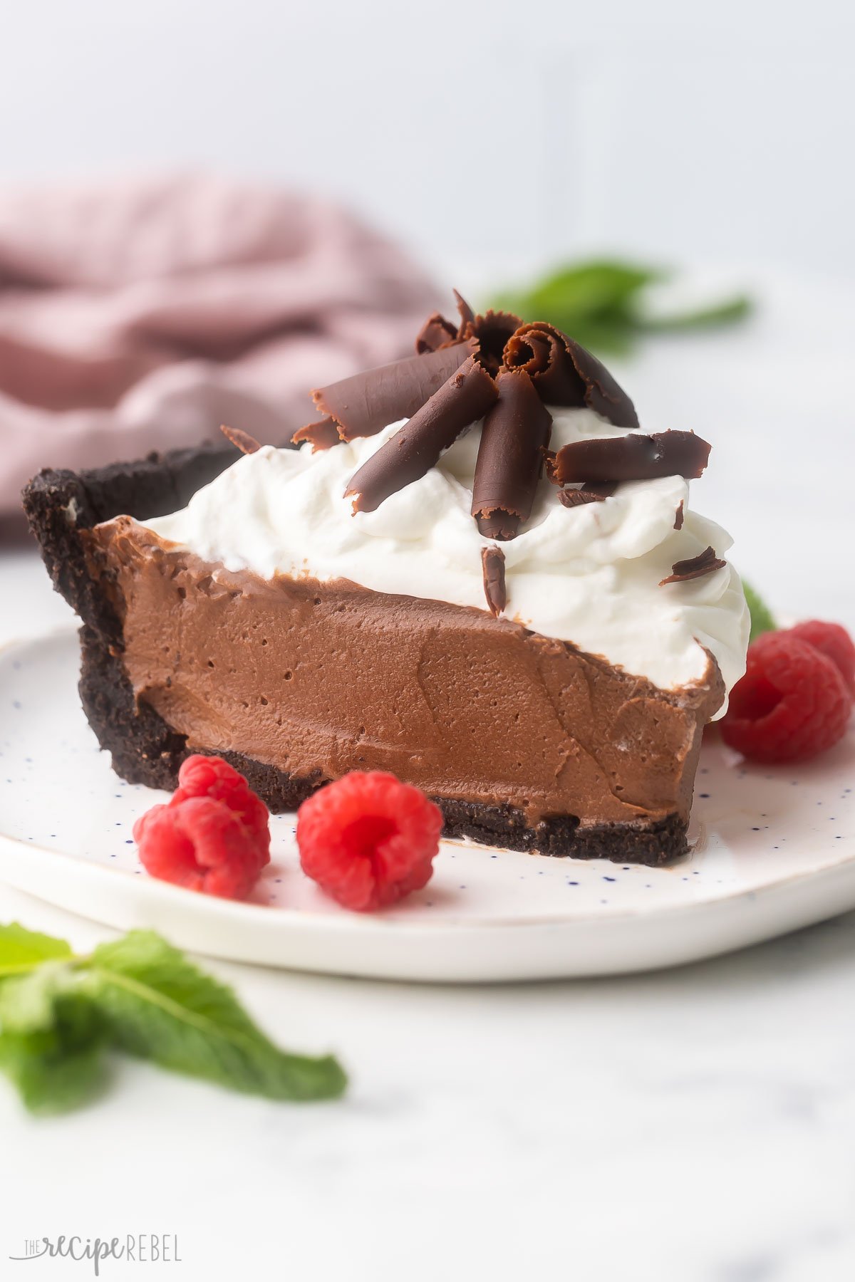 slice of french silk pie on white plate with raspberries.