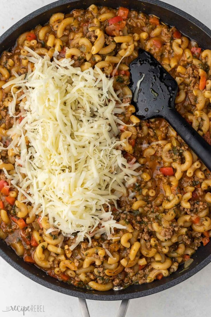 pan of cooked homemade hamburger helper with shredded cheese added on top.