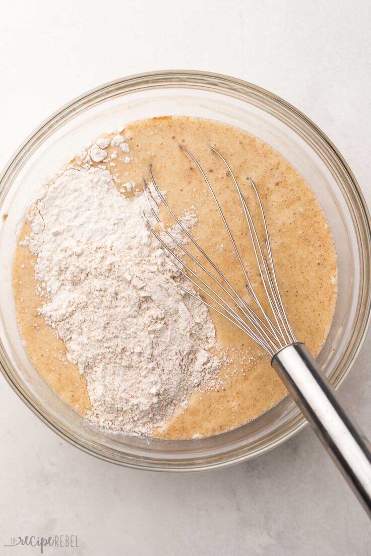 flour added to ingredients in glass mixing bowl.