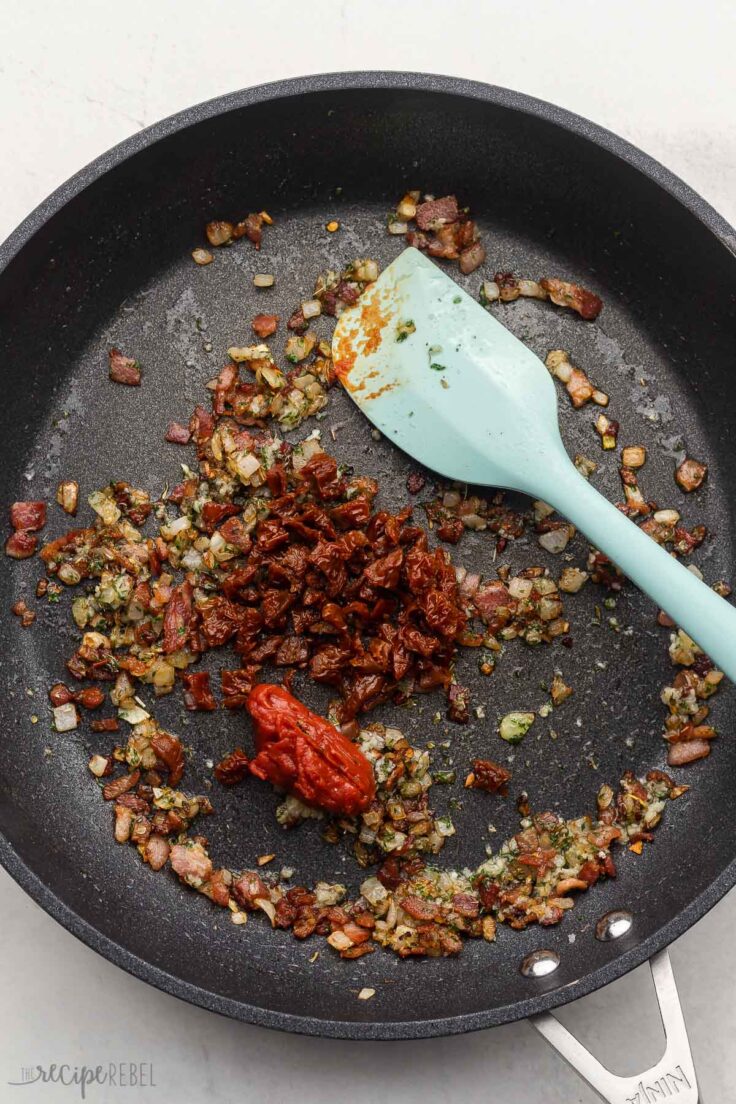 sundried tomatoes and tomato paste added to black pan.