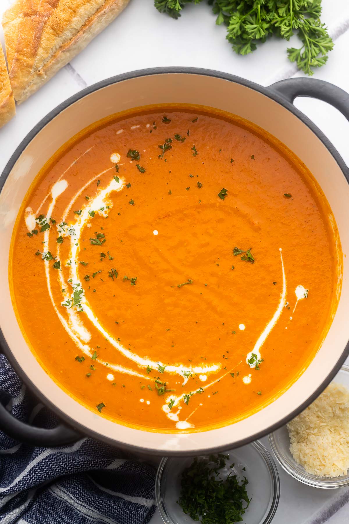 overhead image of roasted red pepper soup in black dutch oven.