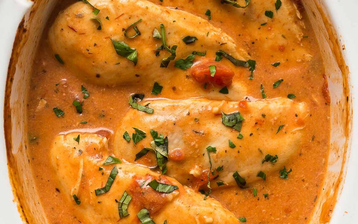 overhead image of slow cooker tomato basil chicken breasts in crockpot.
