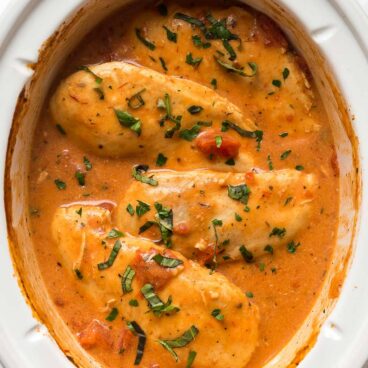 overhead image of slow cooker tomato basil chicken breasts in crockpot.