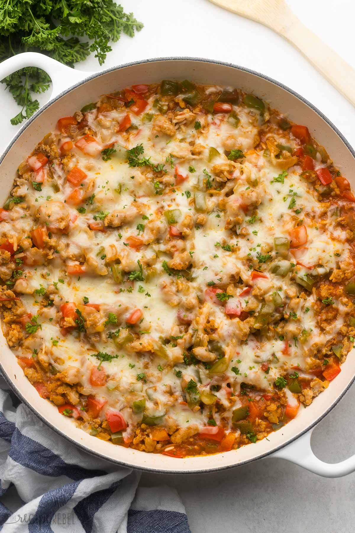 overhead view of stuffed pepper casserole in a white dish with parsley beside.