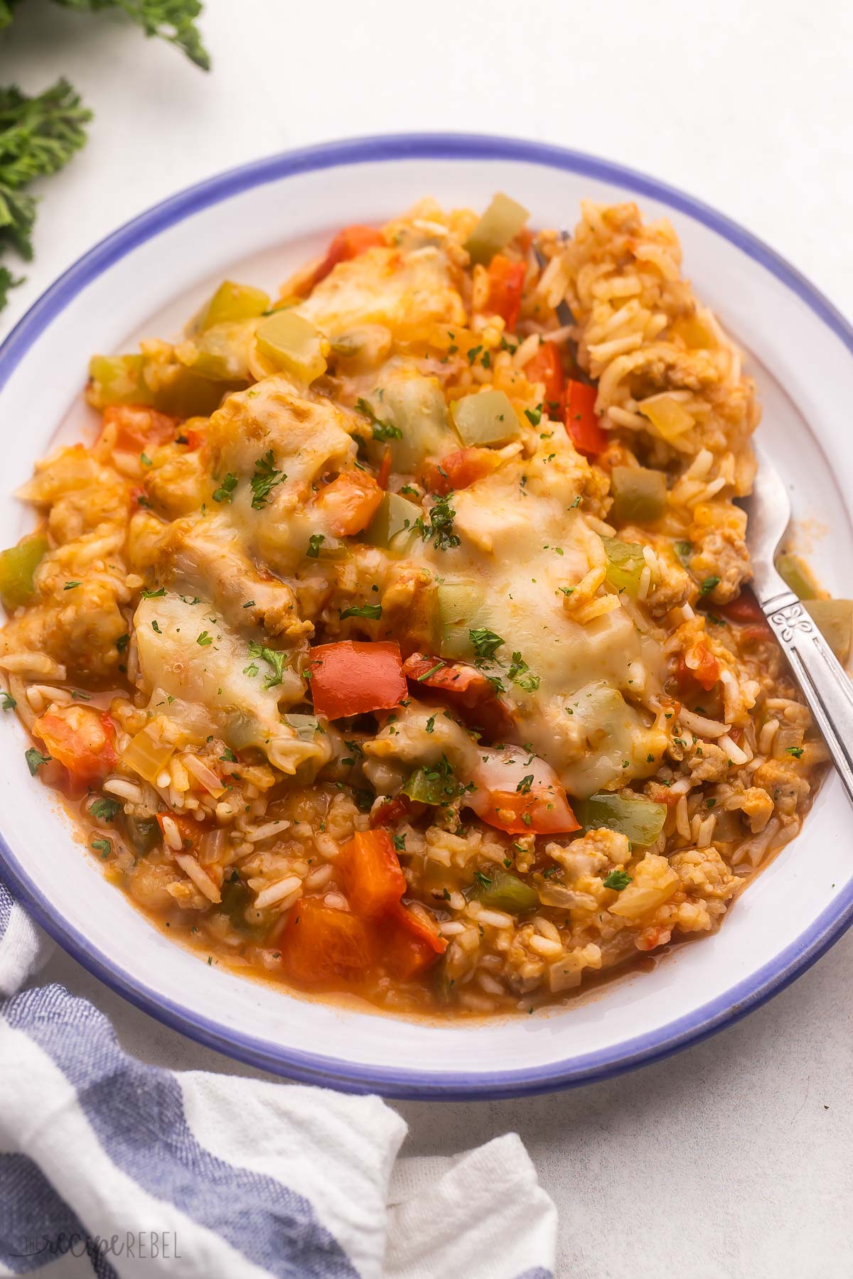 blue and white plate filled with fork and stuffed pepper casserole.