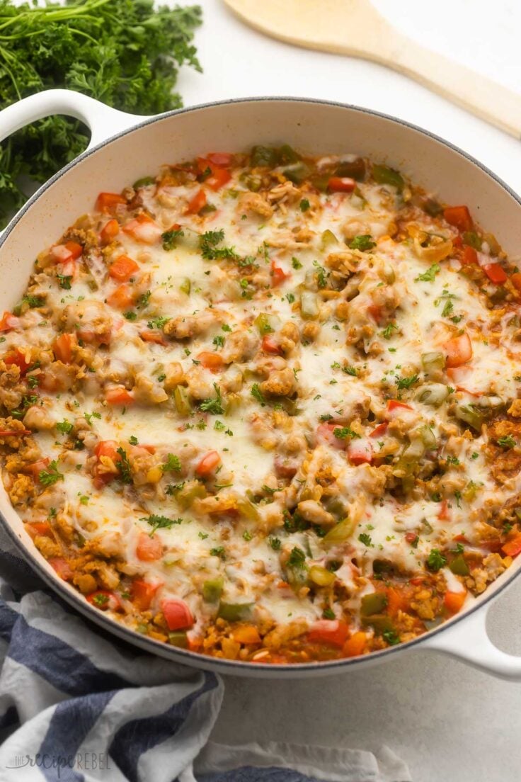 white dish of baked stuffed pepper casserole topped with chopped parsley.