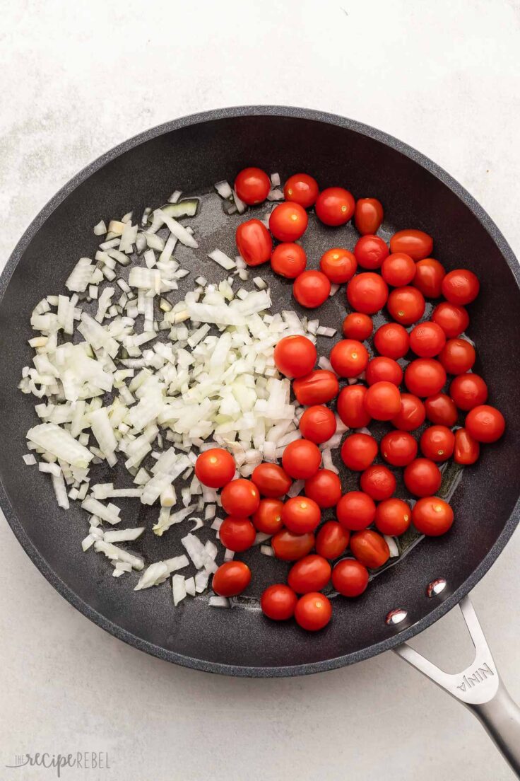 black pan with chopped onions and tomatoes.