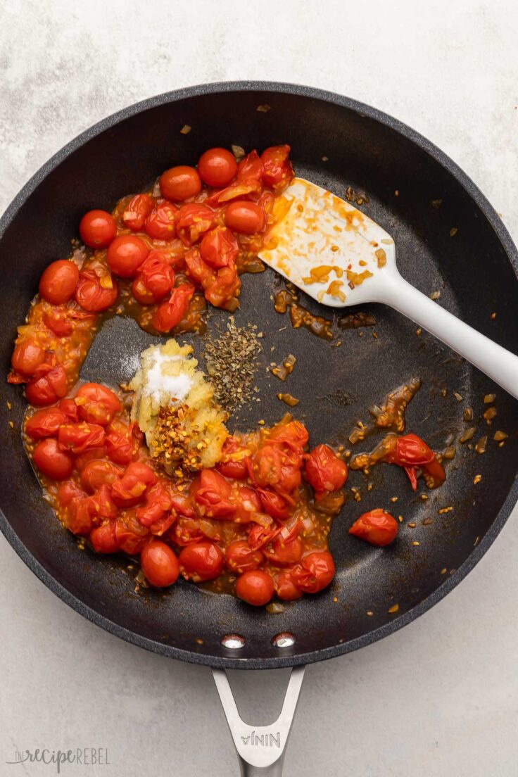 black pan with cooked tomatoes and spices added.