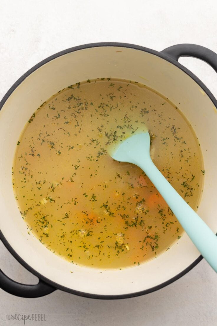 large pot with soup ingredients and broth added.