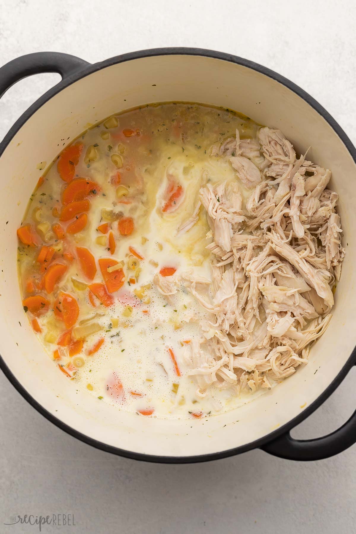 soup ingredients in pot with shredded chicken added.