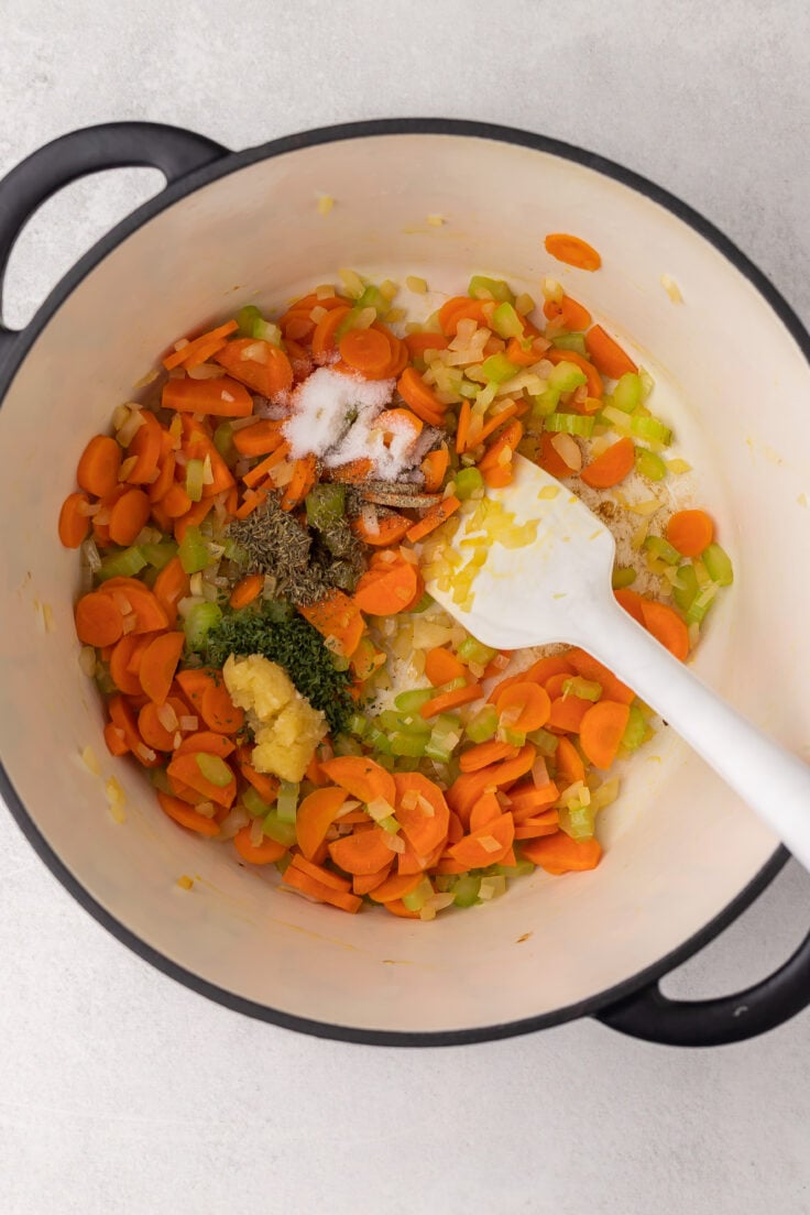 large pot with sauteed vegetables and spices added.