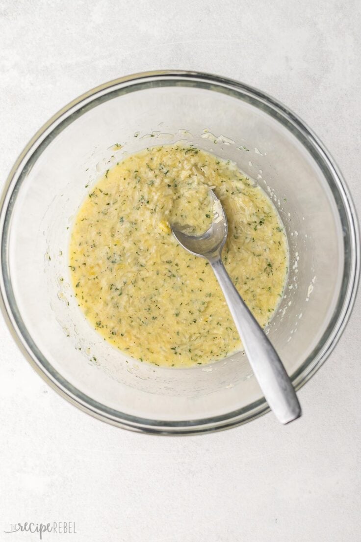 glass mixing bowl with mixed ingredients and spoon.