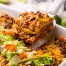 a piece of taco casserole being scooped out of pan.