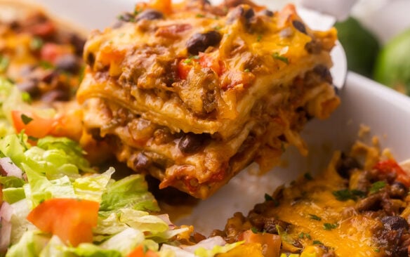 a piece of taco casserole being scooped out of pan.