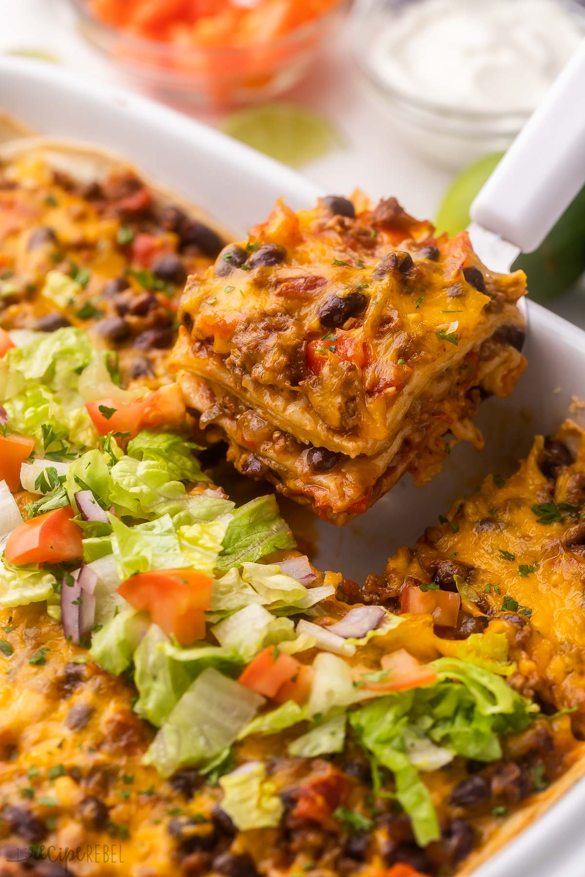 taco casserole being scooped out of pan.