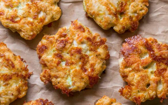 cheesy chicken fritters on a piece of parchment paper.