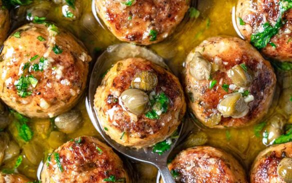 A skillet is filled with chicken piccata meatballs.