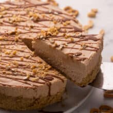 piece of chocolate peanut butter cheesecake being lifted up.