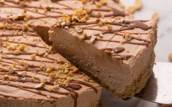 piece of chocolate peanut butter cheesecake being lifted up.