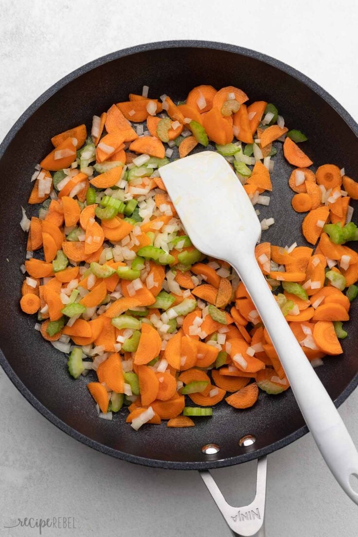 chopped vegetables and spatula in frying pan.