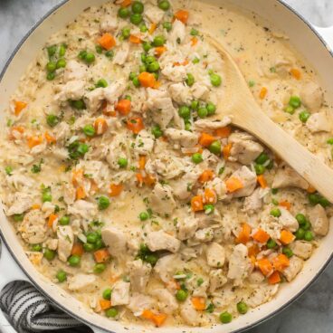 close up of one pan chicken and rice in white baking dish.