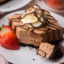 white plate with a nutella cheesecake bar drizzled with chocolate.