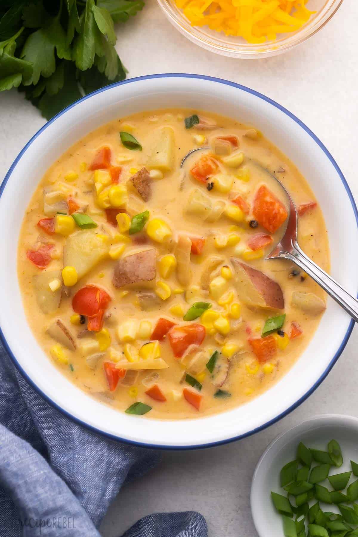white bowl filled with corn chowder and spoon.