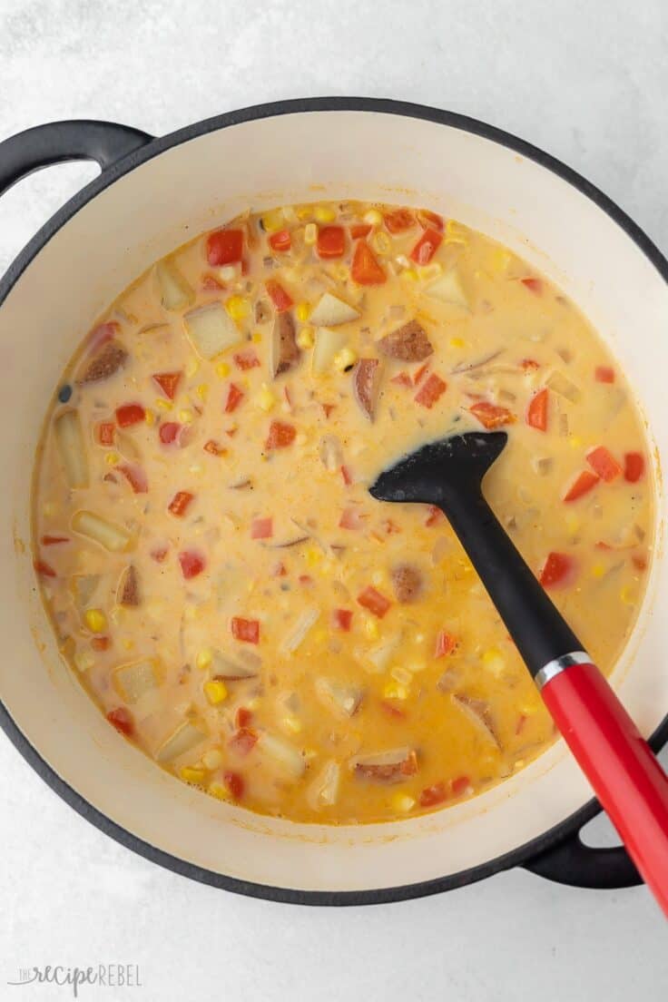large pot of cooked corn chowder with spatula.
