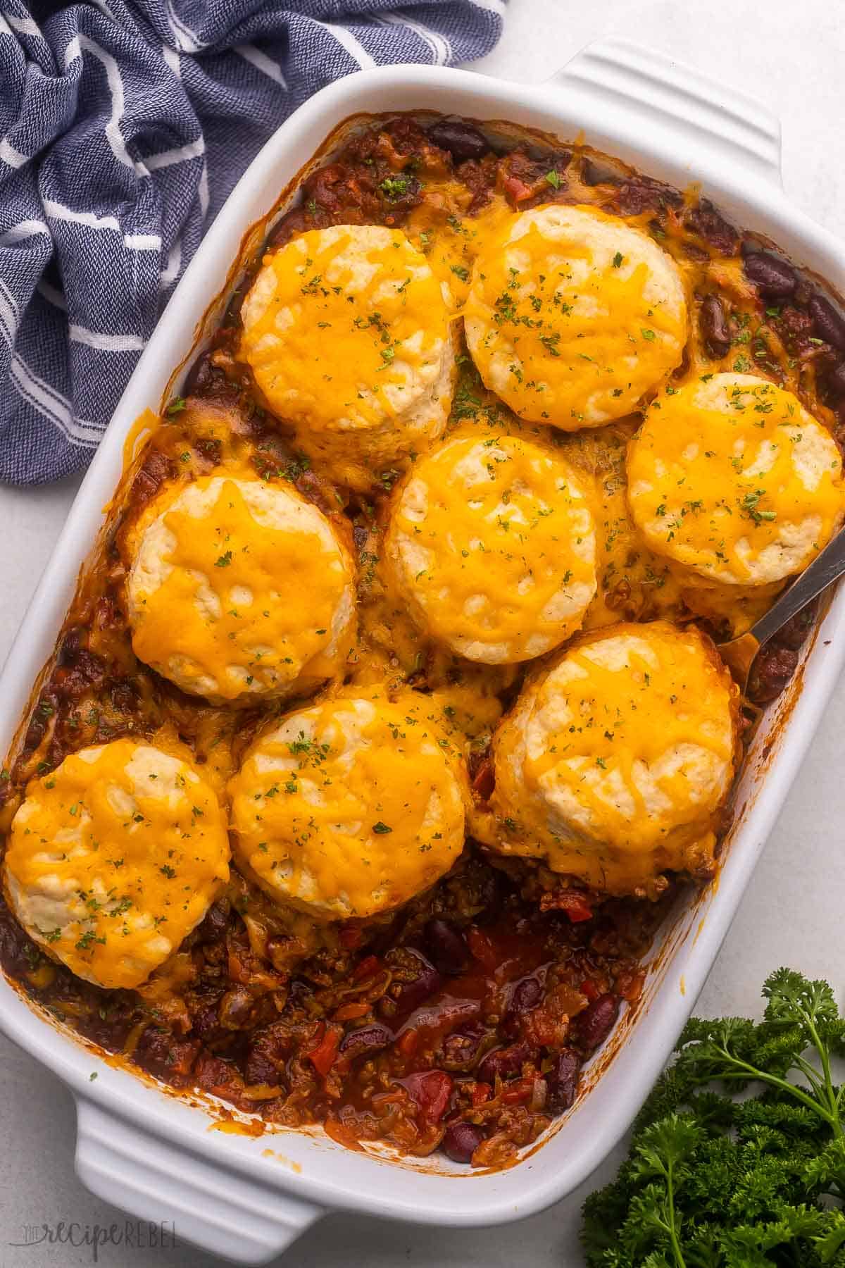 large white pan filled with bbq chili cheese casserole and biscuits on top.
