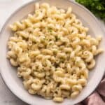 close up of a plate of boursin pasta topped with cracked pepper and chopped parsley.