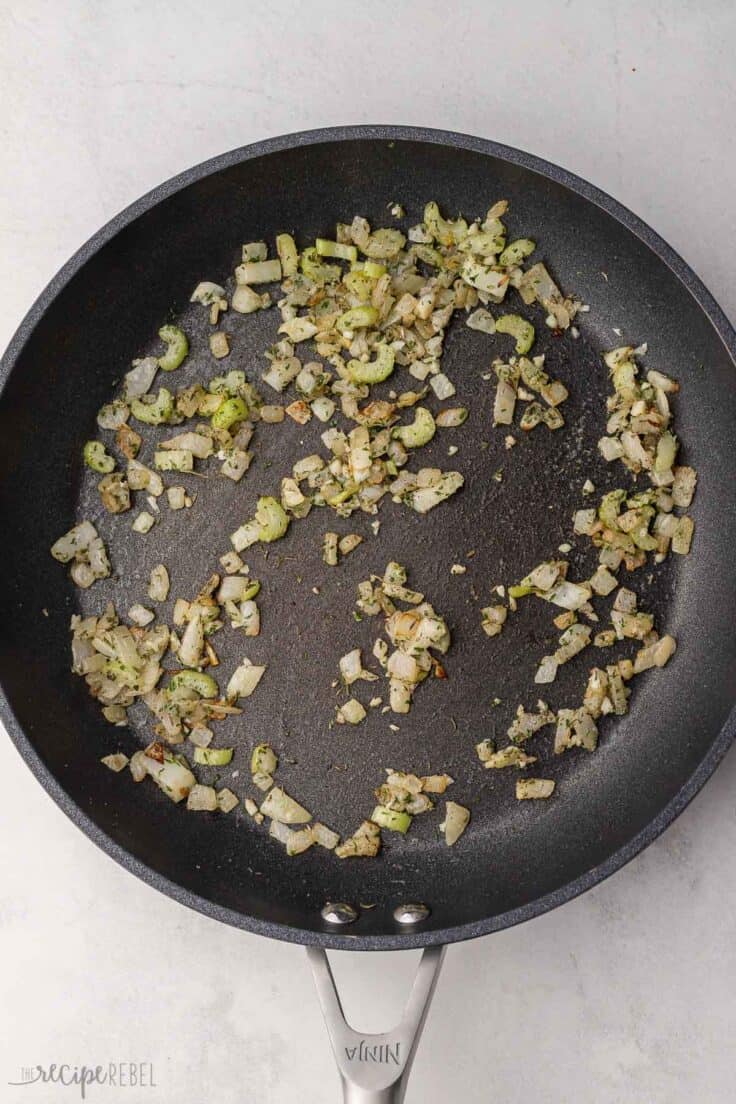 onions and celery sauteeing in a pan with spices.