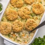 white baking dish full of chicken pot pie casserole with a steel ladle in it.