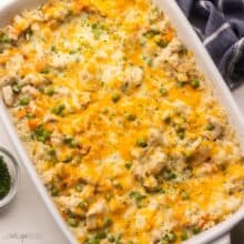 white baking dish full of chicken and rice casserole with chopped parsley beside.