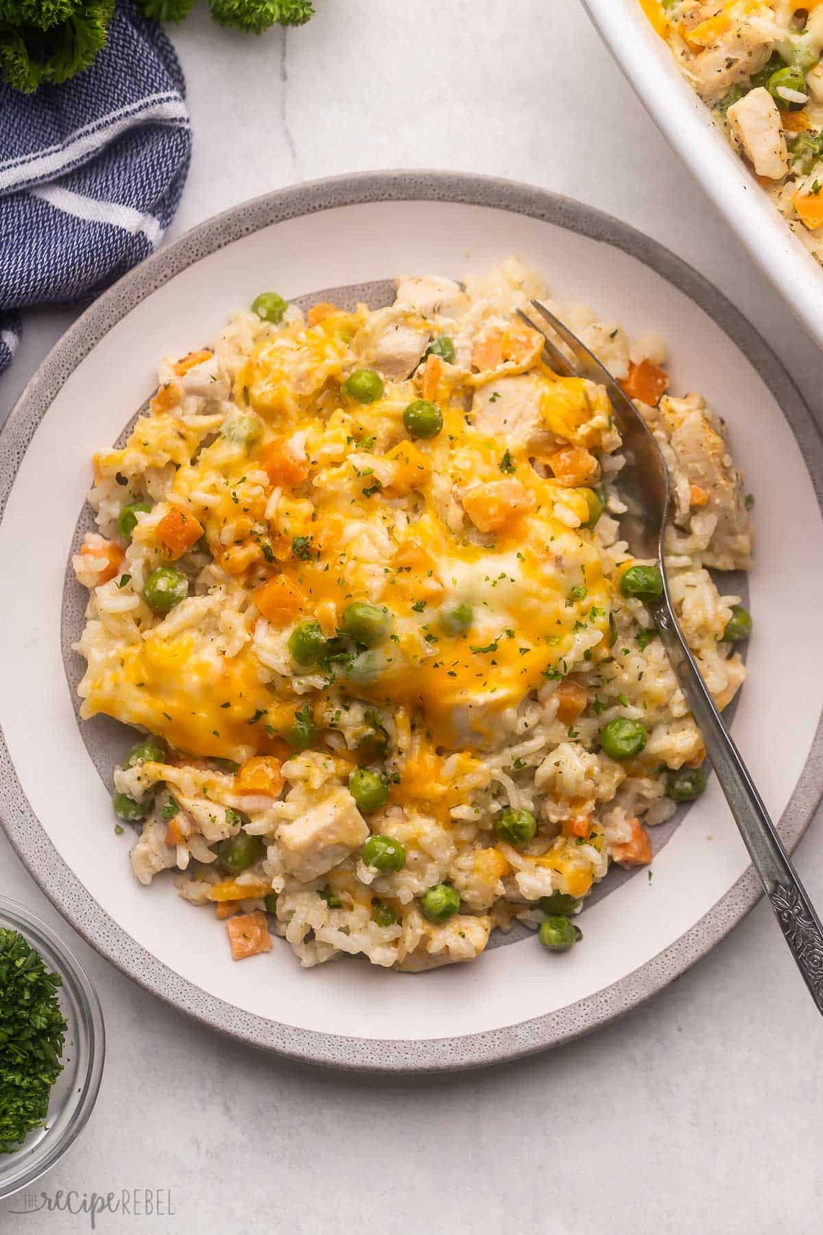 grey and white plate full of chicken and rice casserole with a fork in it.