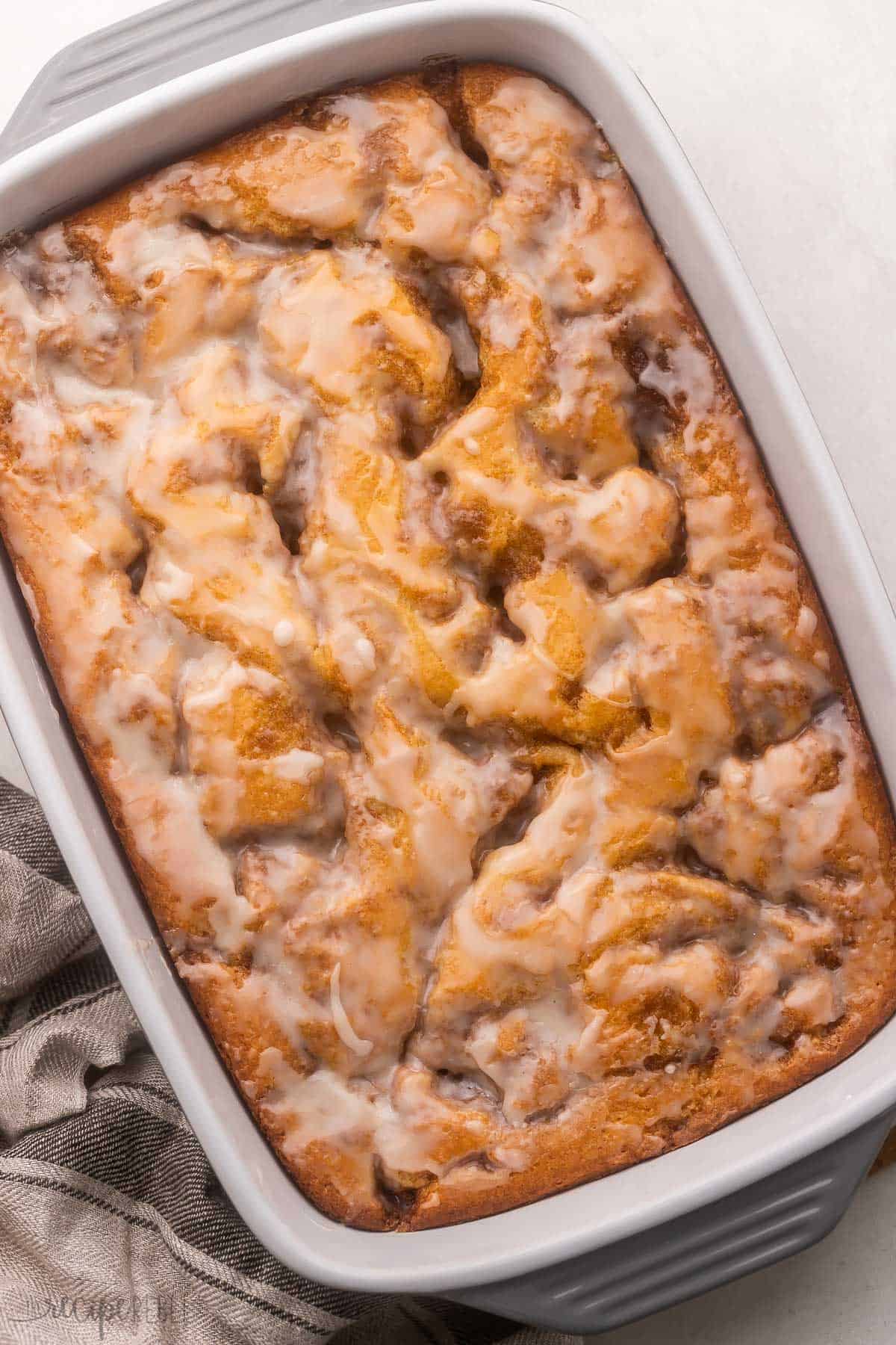 full pan of cinnamon roll cake with glaze on top.